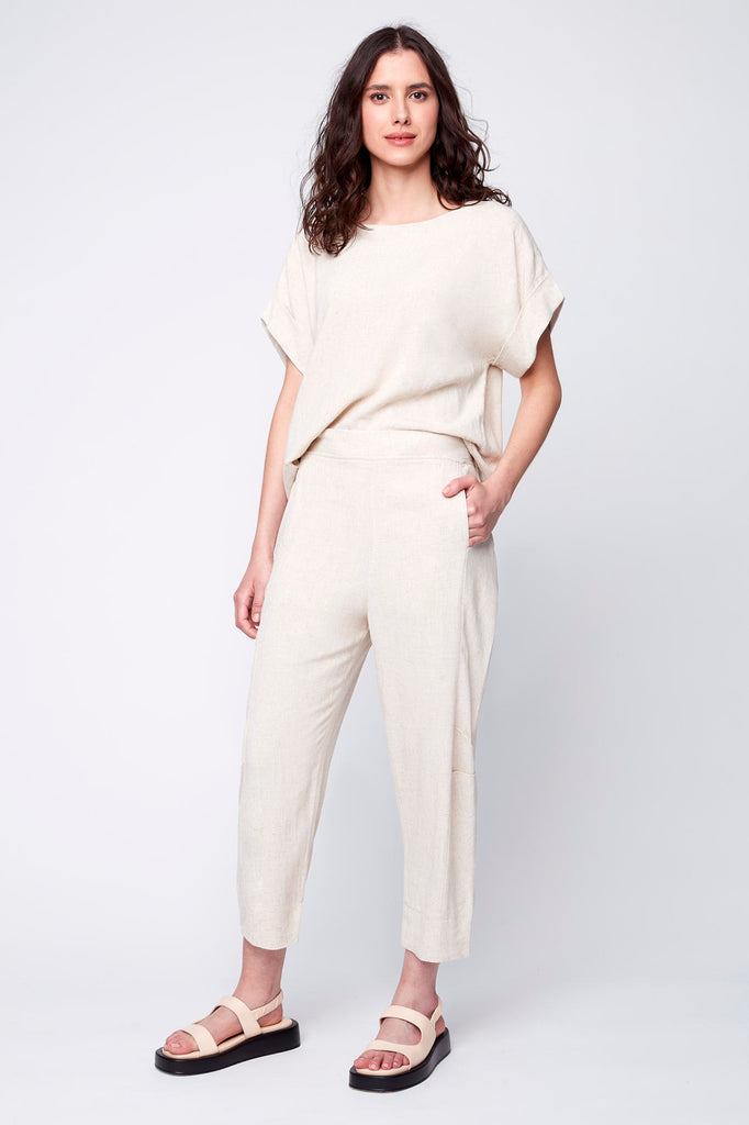 Le pantalon Alice se porte en tenue complète avec son haut Céleste à noeud pour un total look décontracté et chic à la fois. couleur avoine et porté avec des sandales Maguire.