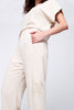 Le pantalon Alice, main dans la poche  se porte en tenue complète avec son haut Céleste à noeud pour un total look décontracté et chic à la fois. couleur avoine 
