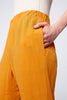 Gros plan sur la taille élastique et la poche du Jogger Lisa de JULEI. Élastique à la taille et aux chevilles. Couleur safran.